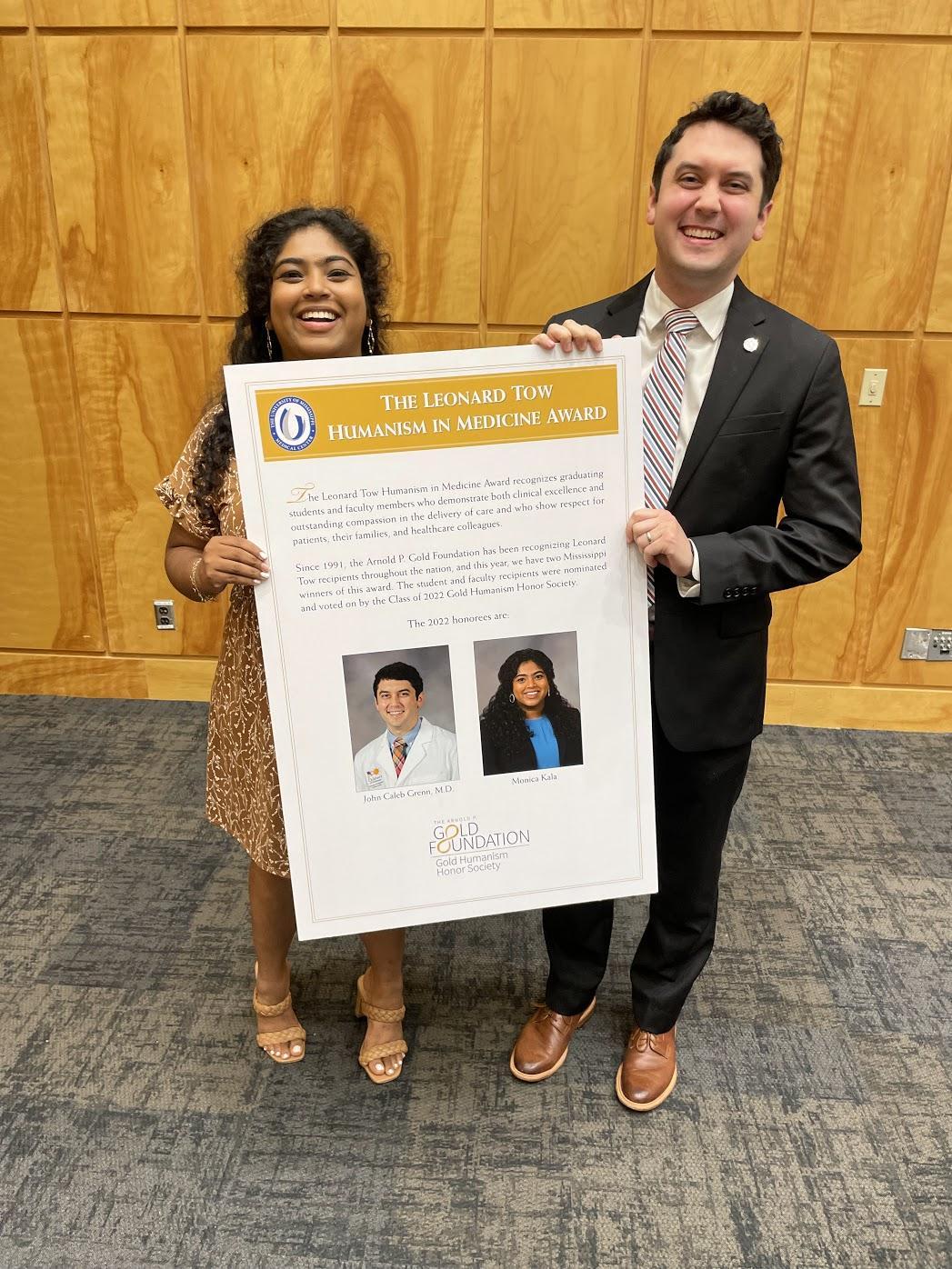 Leonard Tow Humanism in Medicine Award recipients Monica Kala and John Caleb Grenn, MD holding up a recognition poster.